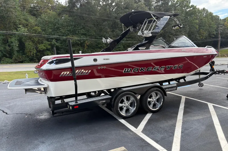 Slide: The Image of 2008 Malibu Wakesetter 23 LSV boat on trailer, red and white design, parked outdoors. - 2