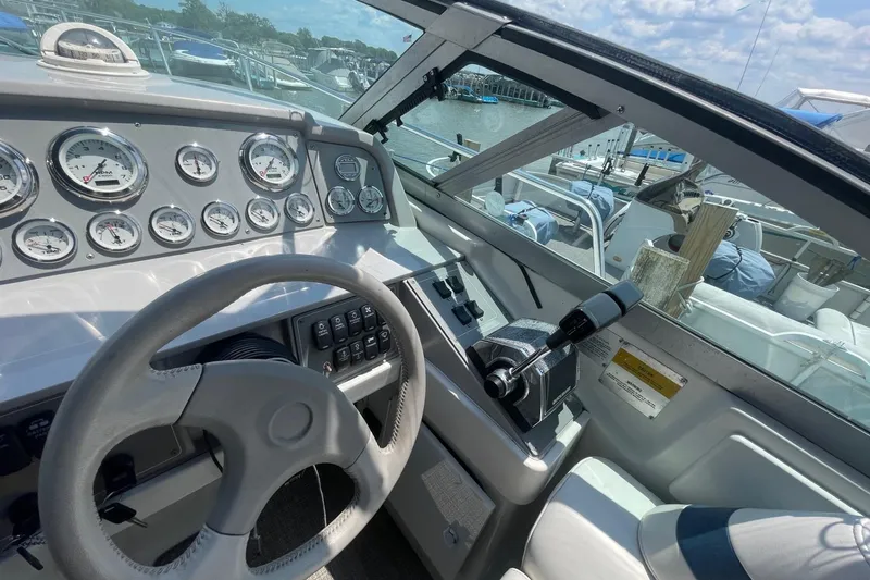 Slide: The Image of 1999 Formula 31 Performance Cruiser dashboard with gauges and controls, docked at marina. - 16