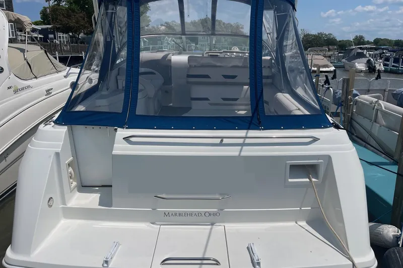 Slide: The Image of 1999 Formula 31 Performance Cruiser docked, featuring blue canopy and white hull. - 2