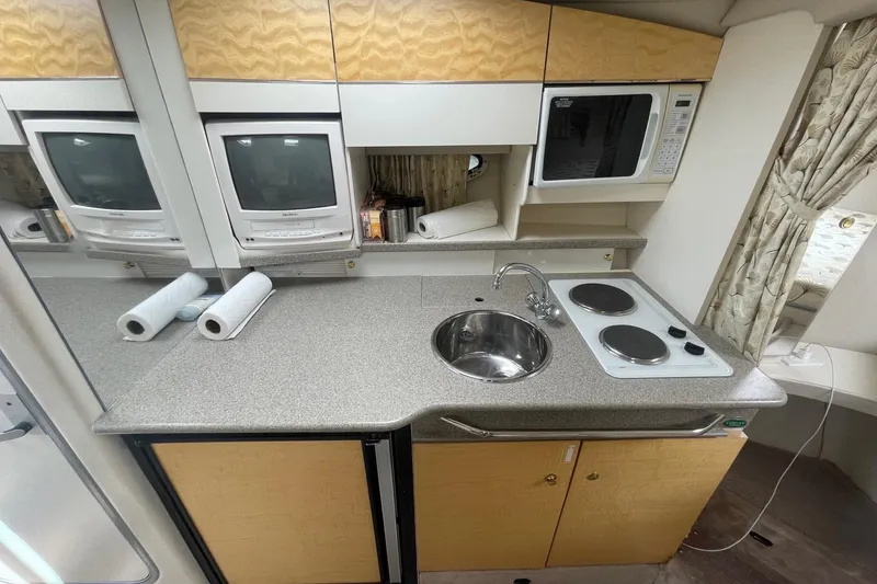 Slide: The Image of 1999 Formula 31 Performance Cruiser interior with bed, kitchenette, and seating area. - 26