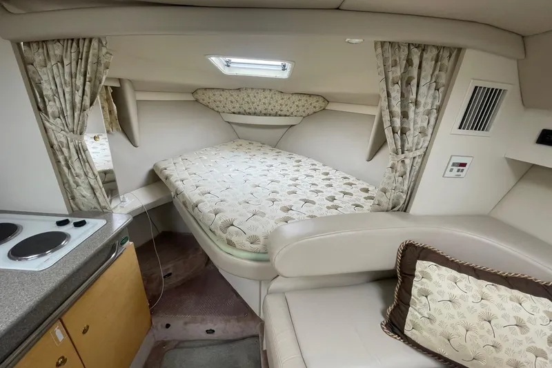 Slide: The Image of 1999 Formula 31 Performance Cruiser interior with beige seating and decorative curtains. - 27