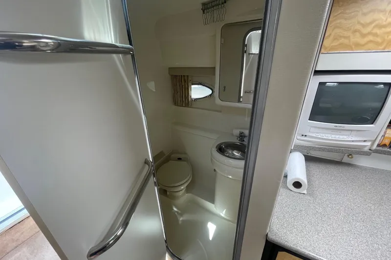 Slide: The Image of 1999 Formula 31 Performance Cruiser bathroom with sink, toilet, and mirror. - 30