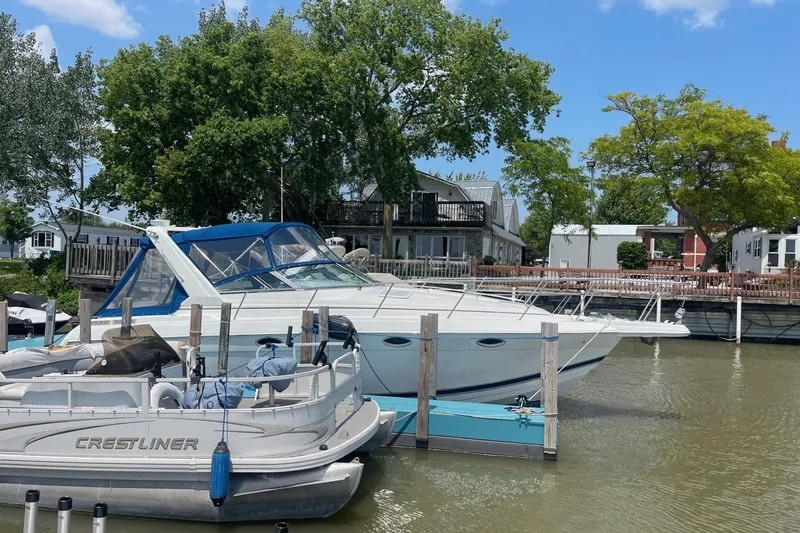 Slide: The Image of 1999 Formula 31 Performance Cruiser docked, featuring blue canopy and sleek white design. - 4