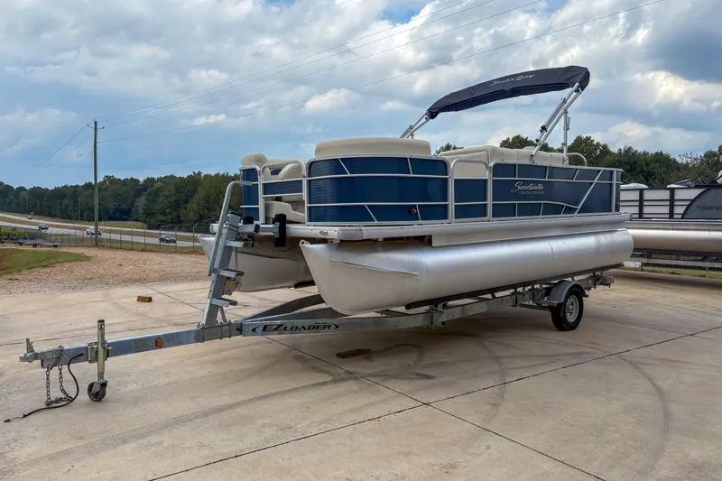 The Image of 2016 Godfrey Sweetwater 2086 C pontoon boat on trailer, parked outdoors. - 1