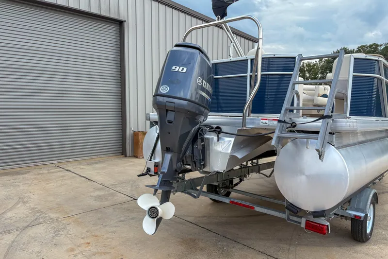Slide: The Image of 2016 Godfrey Sweetwater 2086 C pontoon boat with Yamaha 90 engine, parked near a garage. - 4