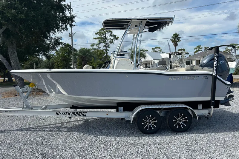 Slide: The Image of 2026 Key West 203 FS boat on trailer, parked outdoors, under cloudy sky. - 6