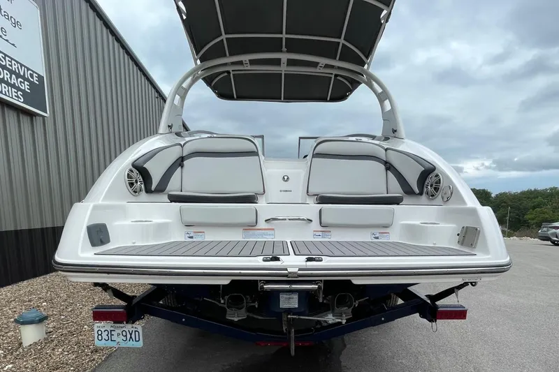 Slide: The Image of 2017 Yamaha 242 boat rear view with seating and speakers, parked outdoors. - 5