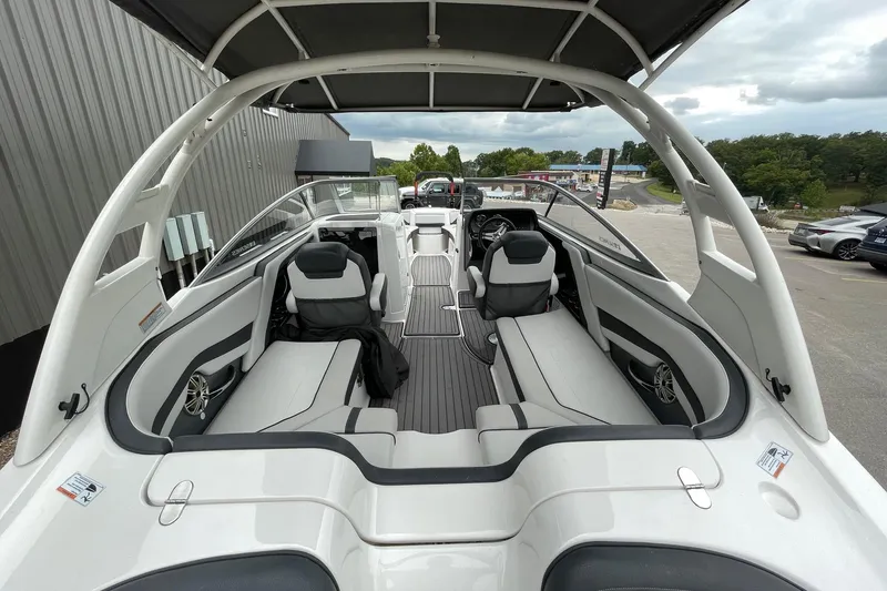 Slide: The Image of 2017 Yamaha 242 boat interior with seating and steering wheel, docked outdoors. - 6