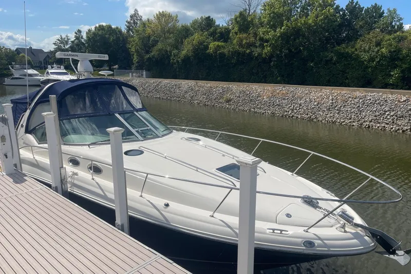 Slide: The Image of 2007 Sea Ray 320 Sundancer docked in a serene marina setting. - 0