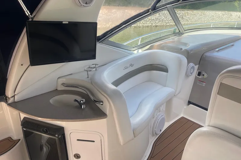 Slide: The Image of 2007 Sea Ray 320 Sundancer interior with seating, sink, and mounted TV. - 10