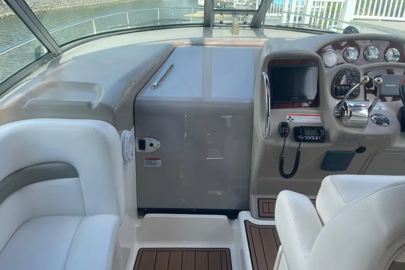 Slide: The Image of 2007 Sea Ray 320 Sundancer helm with modern controls and white seating. - 13