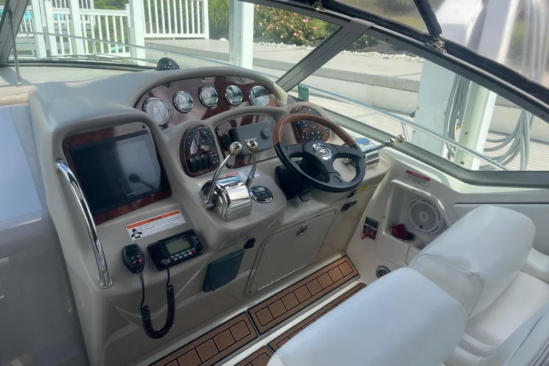 Slide: The Image of 2007 Sea Ray 320 Sundancer helm with steering wheel, gauges, and navigation equipment. - 14