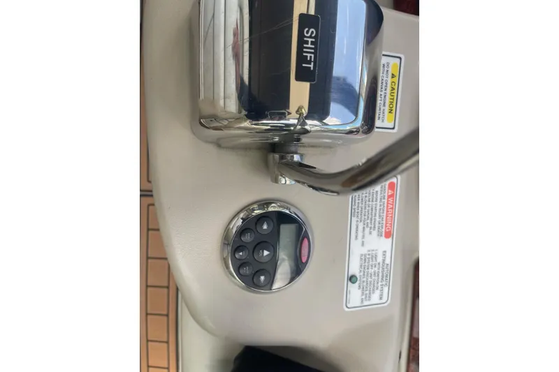 Slide: The Image of Control panel of a 2007 Sea Ray 320 Sundancer boat with shift lever and warning labels. - 20