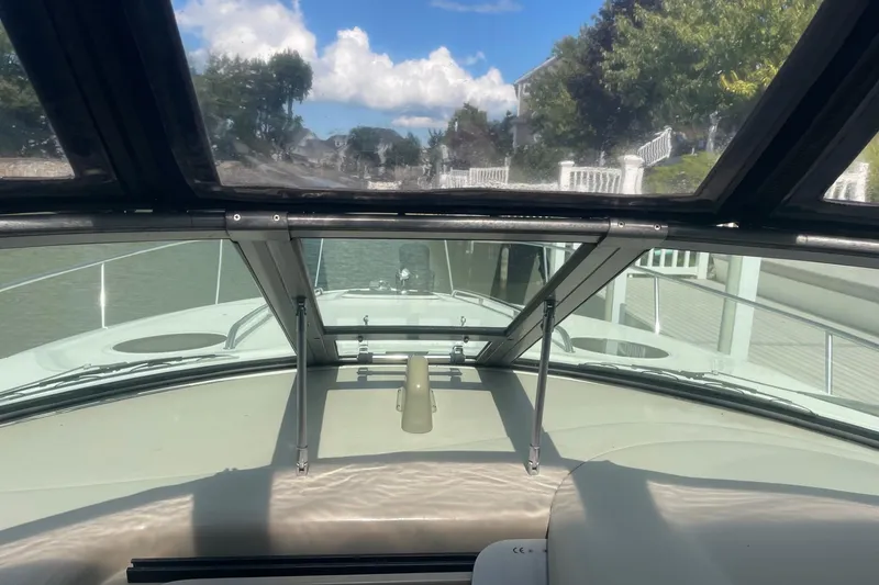 Slide: The Image of 2007 Sea Ray 320 Sundancer cockpit view with clear skies and waterfront scenery. - 21