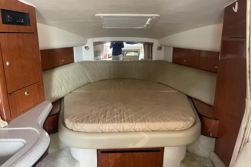 Slide: The Image of 2007 Sea Ray 320 Sundancer cabin interior with bed and wooden cabinetry. - 24