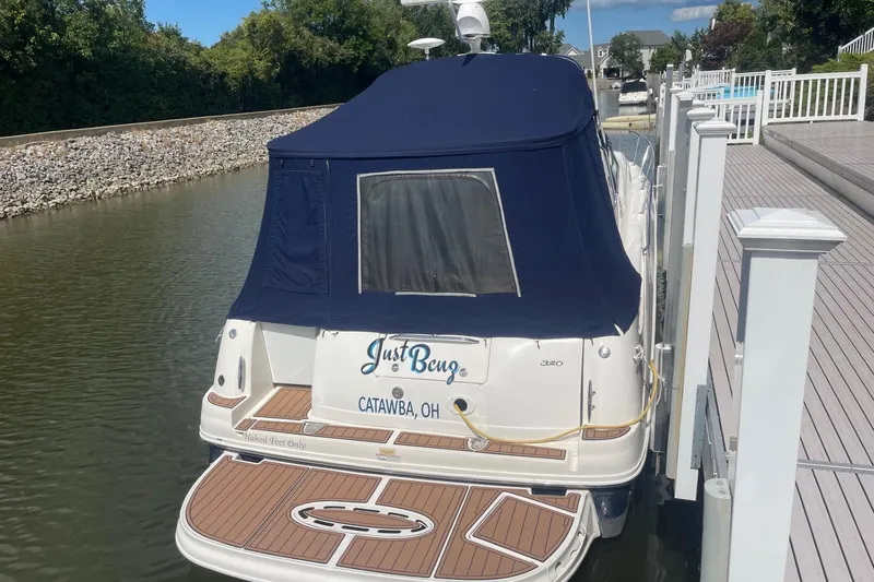Slide: The Image of 2007 Sea Ray 320 Sundancer docked, featuring a blue cover and wooden deck. - 3