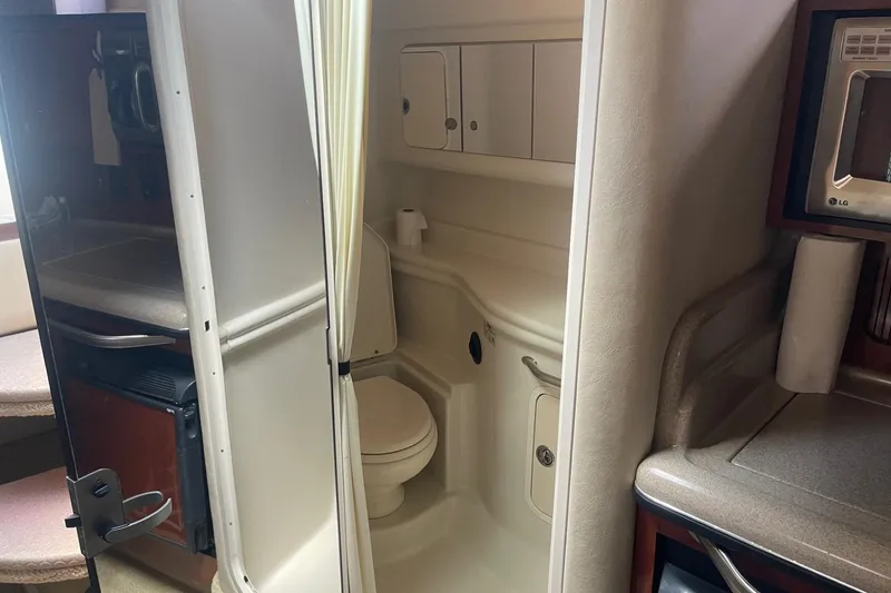 Slide: The Image of 2007 Sea Ray 320 Sundancer interior with compact bathroom and kitchenette. - 30