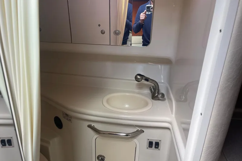 Slide: The Image of 2007 Sea Ray 320 Sundancer bathroom with sink, mirror, and storage cabinets. - 31