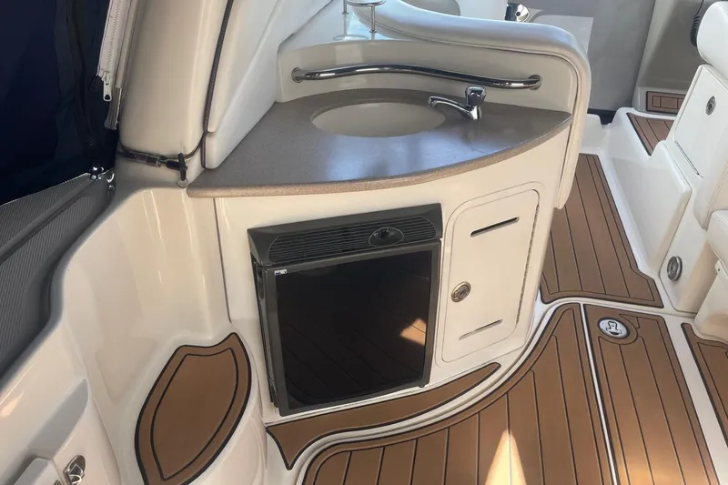 Slide: The Image of 2007 Sea Ray 320 Sundancer interior with sink, mini fridge, and teak flooring. - 6
