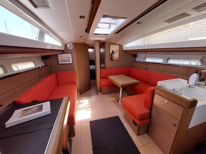 Slide: The Image of 2013 Jeanneau Sun Odyssey 44 DS sailboat deck with wooden seating, docked in marina. - 38