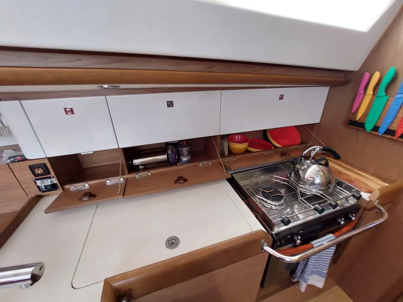 Slide: The Image of Interior of 2013 Jeanneau Sun Odyssey 44 DS with red sofa and navigation equipment. - 52