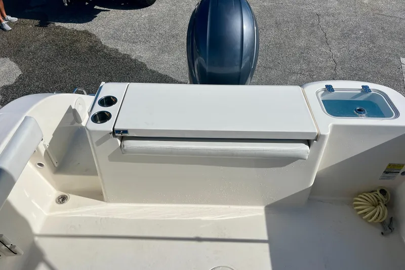 Slide: The Image of 2023 Cobia 200 DC boat stern with seating, cup holders, and storage compartment. - 12