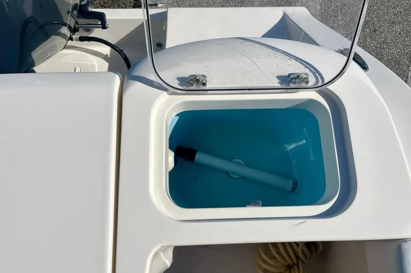 Slide: The Image of 2023 Cobia 200 DC boat livewell with open lid and blue interior. - 13