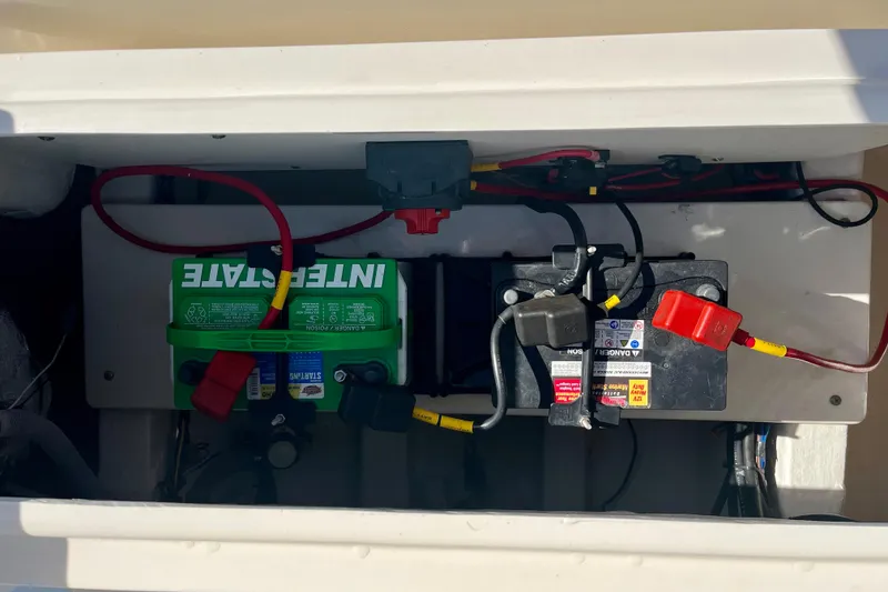 Slide: The Image of 2023 Cobia 200 DC boat battery compartment with Interstate battery and wiring. - 15