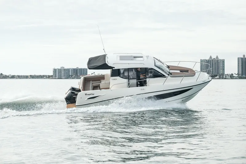 Slide: The Image of 2026 Trophy T29 Explorer boat cruising on water with city skyline in background. - 5