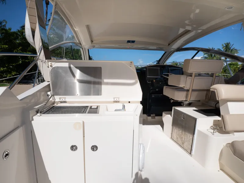 Slide: The Image of 2014 Pursuit SC 365i Sport Coupe interior with helm, seating, and kitchenette. - 11