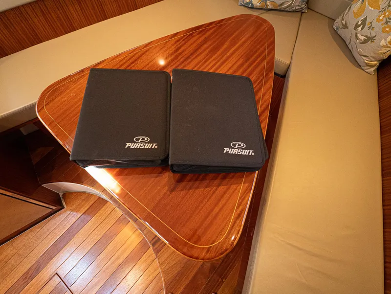 Slide: The Image of Interior of 2014 Pursuit SC 365i Sport Coupe with wooden table and branded folders. - 16