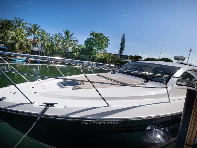 Slide: The Image of 2014 Pursuit SC 365i Sport Coupe docked by tropical waterfront. - 2