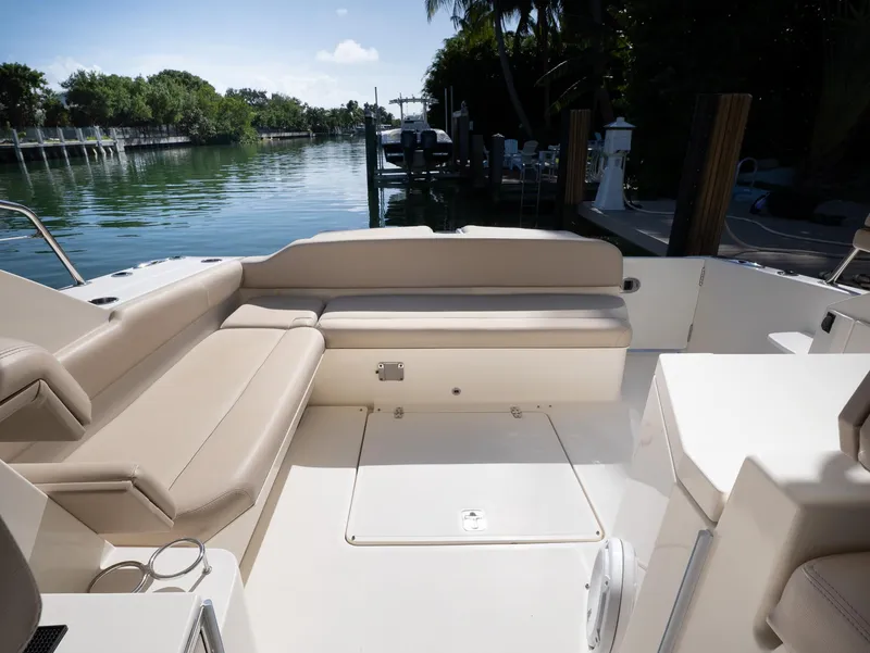 Slide: The Image of 2014 Pursuit SC 365i Sport Coupe interior with beige seating, docked by a serene waterway. - 5