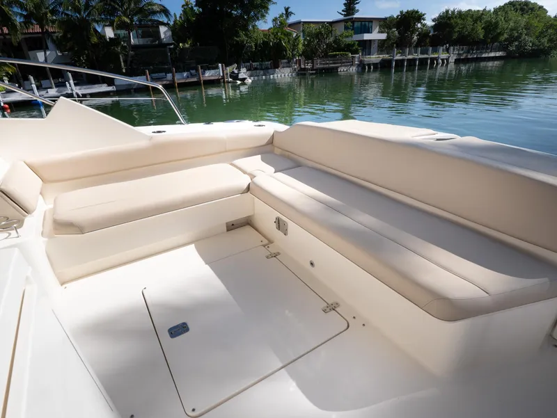 Slide: The Image of 2014 Pursuit SC 365i Sport Coupe interior with beige seating by the water. - 6