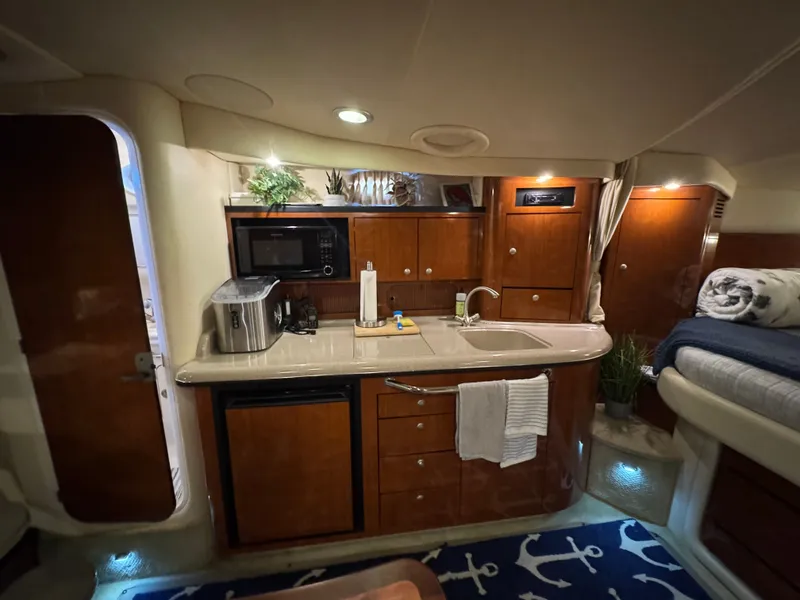 Slide: The Image of Interior of 2007 Sea Ray 340 Sundancer yacht with kitchenette and cozy sleeping area. - 13