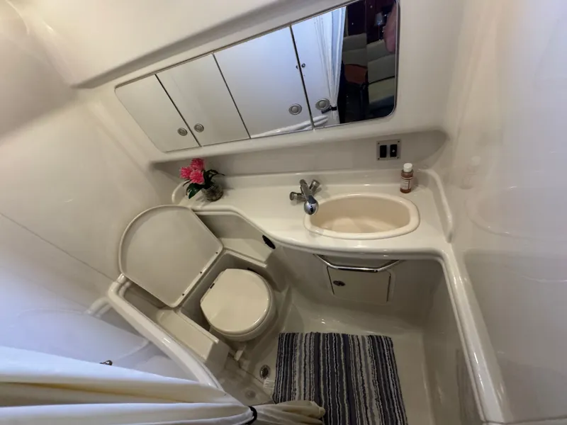 Slide: The Image of Bathroom interior of 2007 Sea Ray 340 Sundancer yacht, featuring sink, toilet, and mirror cabinet. - 21