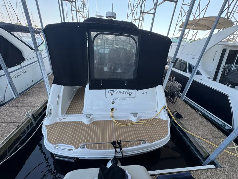 Slide: The Image of 2007 Sea Ray 340 Sundancer docked, featuring a black canopy and wooden deck. - 5