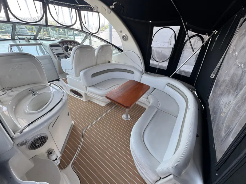 Slide: The Image of 2007 Sea Ray 340 Sundancer interior with white seating, wooden table, and helm station. - 6