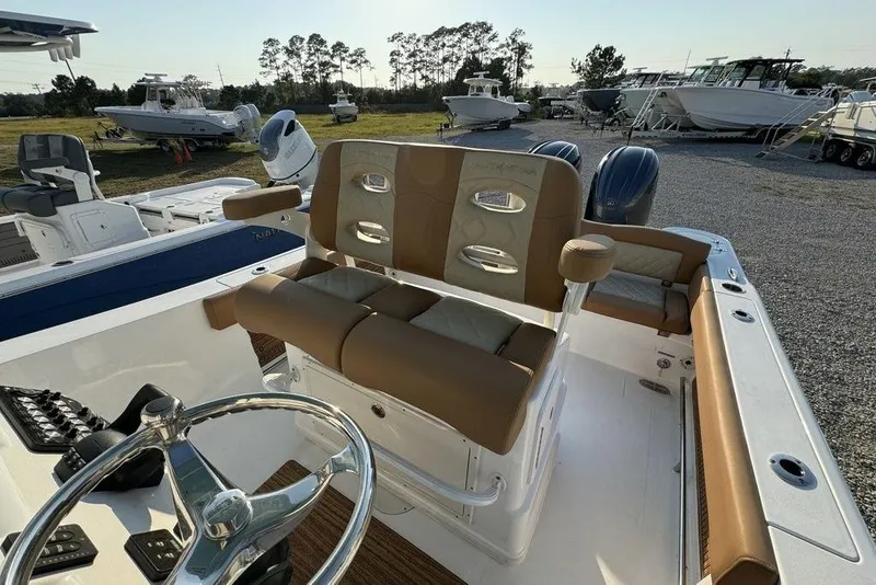 Slide: The Image of 2024 NauticStar 252 Legacy boat interior with dual seats and steering wheel. - 19