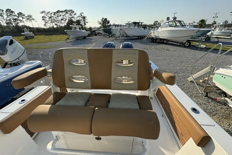 Slide: The Image of 2024 NauticStar 252 Legacy boat with tan seating, parked among other boats. - 20