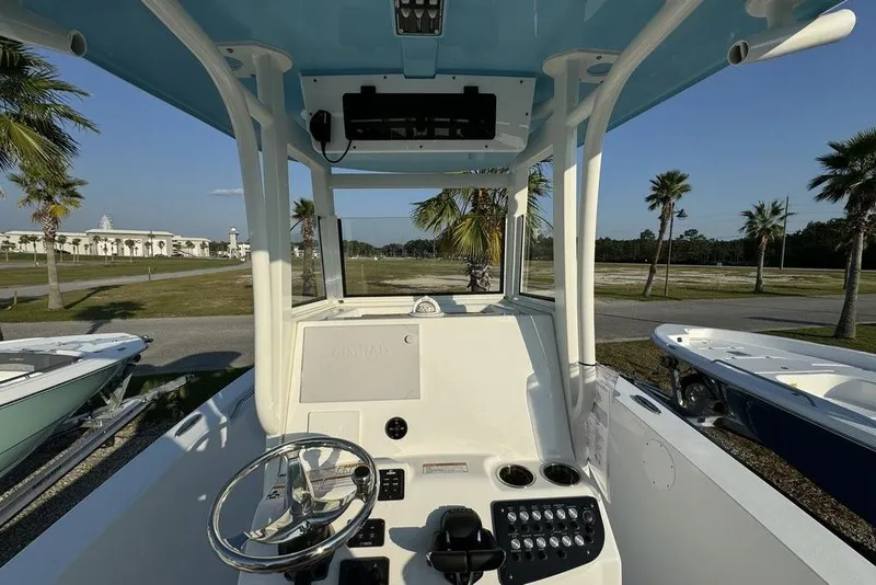 Slide: The Image of 2024 NauticStar 252 Legacy boat helm with steering wheel and control panel. - 23