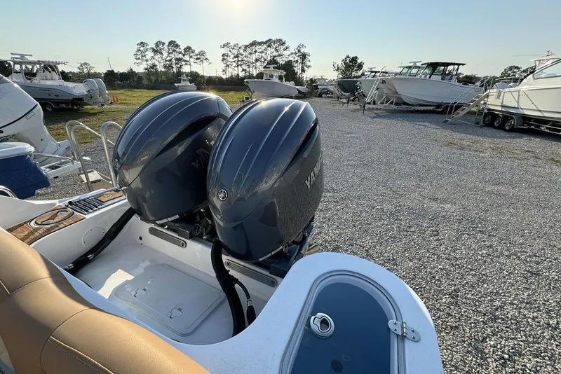 Slide: The Image of 2024 NauticStar 252 Legacy boat with dual Yamaha engines in a marina setting. - 29