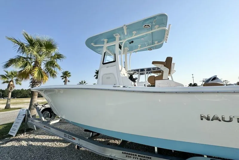 Slide: The Image of 2024 NauticStar 252 Legacy boat on trailer, surrounded by palm trees, under clear blue sky. - 4