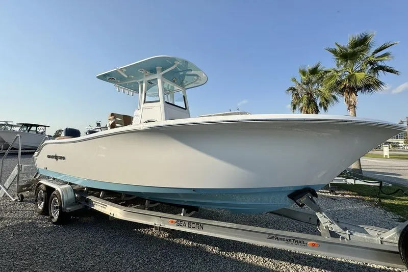 Slide: The Image of 2024 NauticStar 252 Legacy boat on trailer, parked outdoors with palm trees. - 7