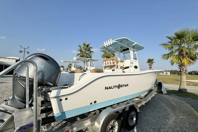 Slide: The Image of 2024 NauticStar 252 Legacy boat on trailer, sunny day, palm trees in background. - 8