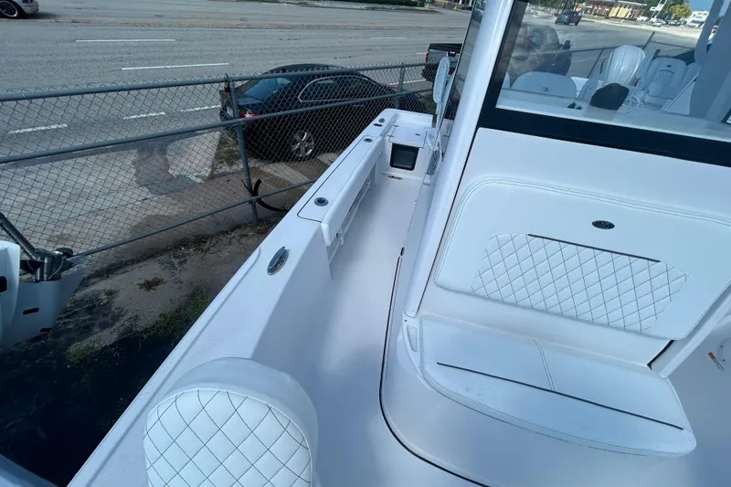 Slide: The Image of 2025 Sportsman Masters 227 Bay Boat interior with white seating and sleek design. - 12