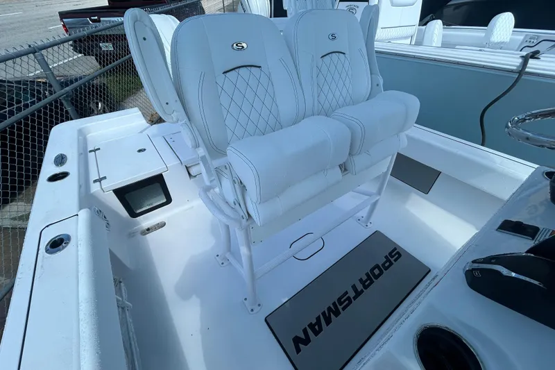 Slide: The Image of 2025 Sportsman Masters 227 Bay Boat interior with white seating and logo mat. - 13