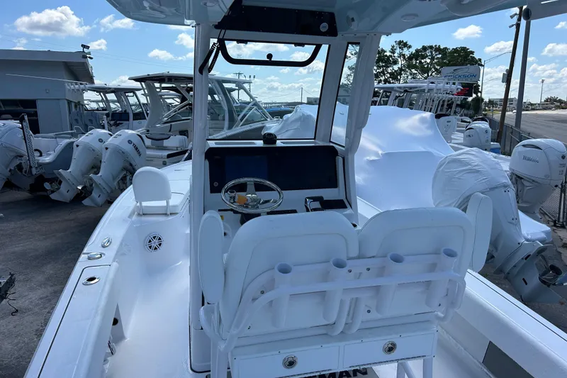 Slide: The Image of 2025 Sportsman Masters 227 Bay Boat with dual seating and modern console, docked outdoors. - 15