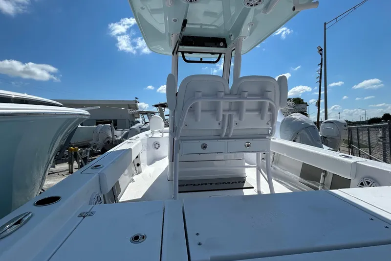 Slide: The Image of 2025 Sportsman Masters 227 Bay Boat interior with seating and console under clear blue sky. - 7