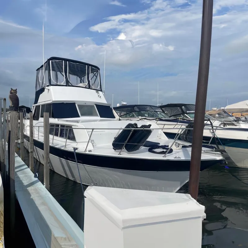 Slide: The Image of 1985 Marinette DC 39 boat docked at marina, featuring a sleek design and spacious deck. - 0
